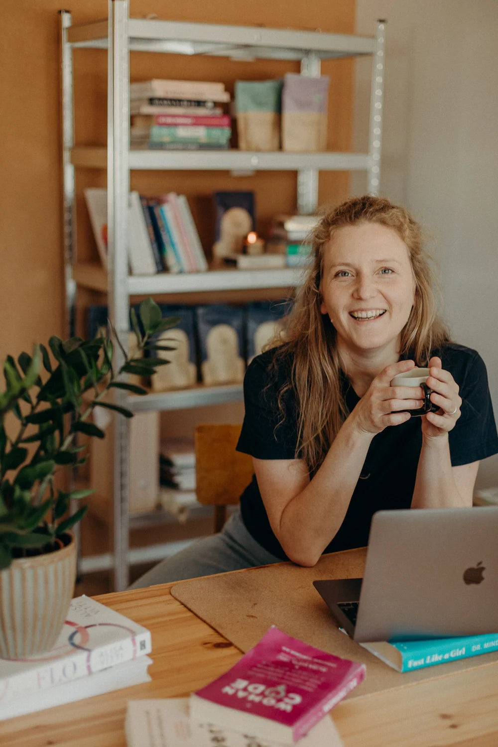 Woman smiling at her desk with a cup of cacao