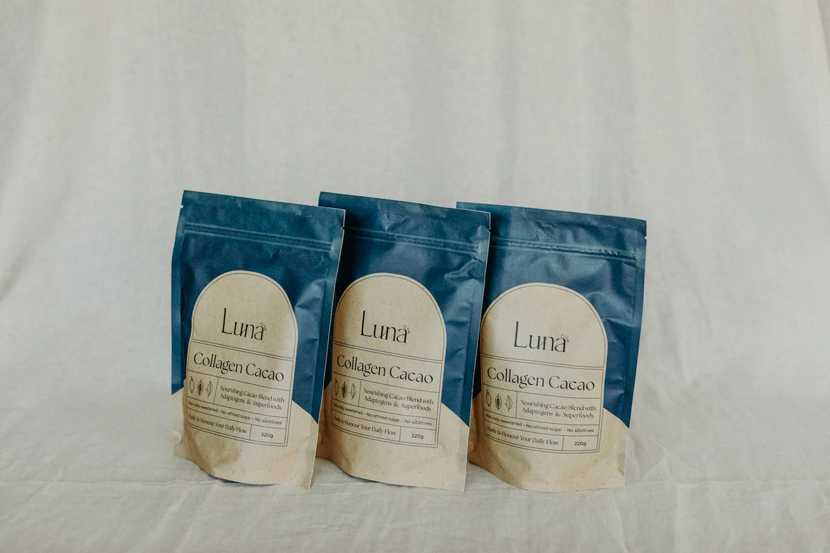 Three bags of Luna Collagen Cacao on linen